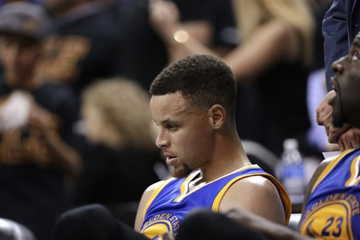 Golden State Warriors guard Stephen Curry sits on the bench against the Cleveland Cavaliers during the second half of Game 6 of basketball's NBA Finals in Cleveland Thursday