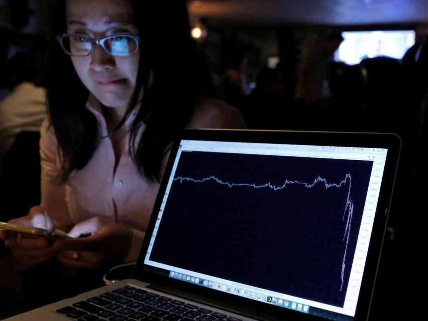 A woman watching the Brexit vote in The Churchill Tavern a British themed pub reacts as a graph shows the British Pound falling in value following the announcement that Britain would leave the European Union in the Manhattan borough of New York U.S