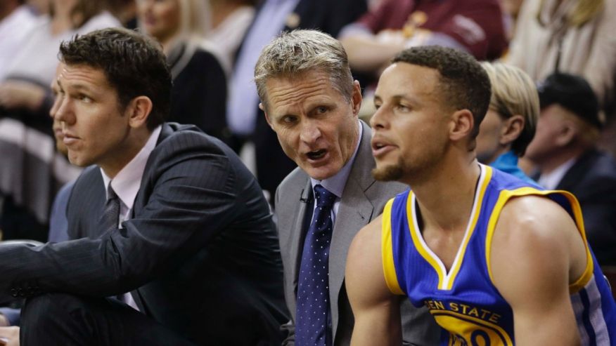 Golden State Warriors coach Steve Kerr center talks with guard Stephen Curry on the bench during the first half against the Cleveland Cavaliers in Game 3 of basketball's NBA Finals in Cleveland