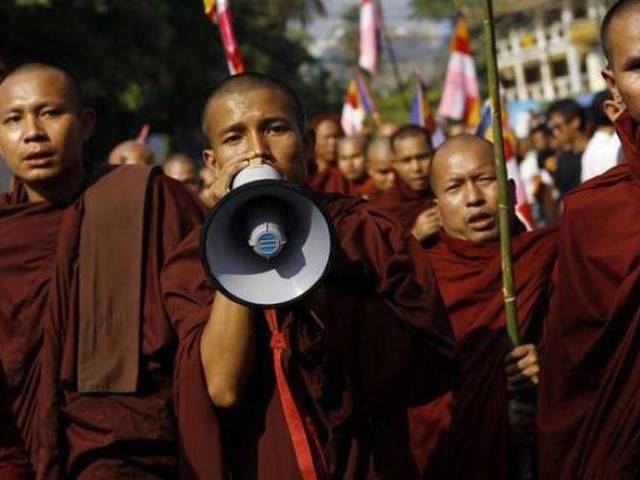 Buddhist monks take part in a protest in support of demonstrators who were injured during a copper mine riot in Yang