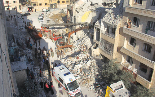 Syrian Civil Defence members search on Tuesday for survivors amid the rubble following airstrikes the previous night on the city of Idlib