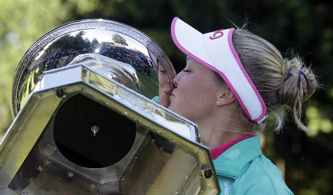 Brooke Henderson plants a kiss on the championship trophy after winning the Women's PGA Championship golf tournament at Sahalee Country Club on Sunday