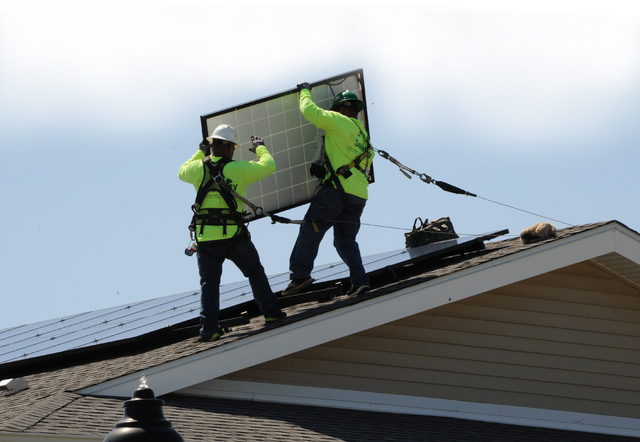 CRAIG T. KOJIMA  MAY 8 2013           Solar City foremen Shelton Guerrero left and Quinton Kamaunu install solar panel on roof of home. Solar City Marine Corps Base Hawaii and Navy Region Hawaii launch a project to install sola