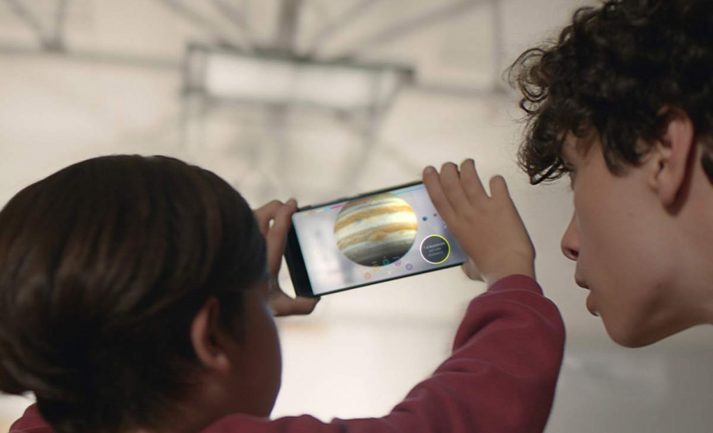 This image provided by Google shows people looking at a view of the solar system using technology Google calls'Project Tango