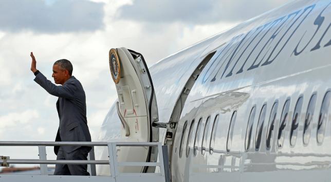 US President Barack Obama waves as he steps out of Air Force One upon his arrival in Miami Florida US