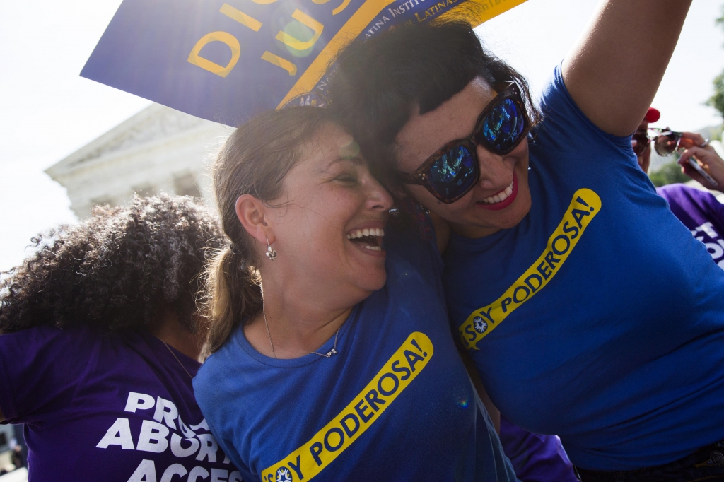 Bethany Van Kampen left hugs Alejandra Pablus as they celebrate during a rally at the Supreme Court in Washington Monday