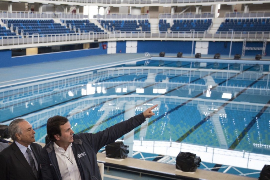 Brazil's interim President Michel Temer left talks to Rio de Janeiro Mayor Eduardo Paes as they visit the Olympic Aquatics Stadium at the Olympic Park in Rio de Janeiro Tuesday. Temer has stepped up his pledges of support for the Olympic games whi