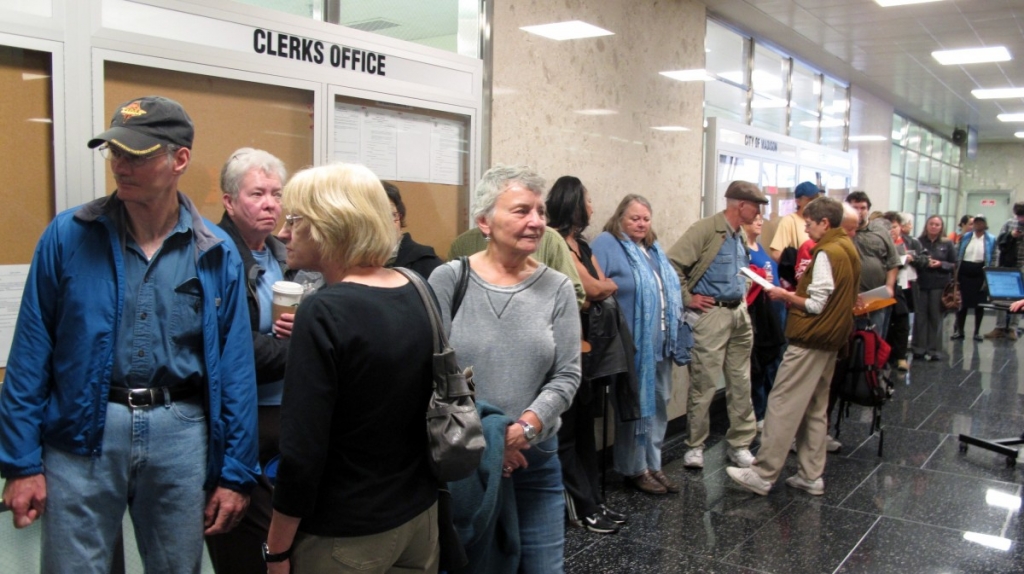 Voters line up outside the Madison city clerk's office to be among the first to cast ballots early for the Nov. 6 election on Monday Oct. 22 2012 in Madison Wis. Wisconsin is one of just nine states where both President Barack Obama and Republican Mit