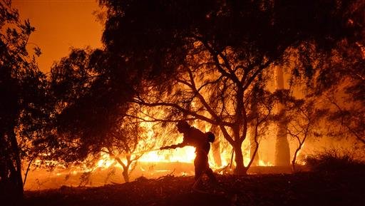 Santa Barbara County Fire Department a firefighter knocks down flames as they approach a ranch near the Las Flores Canyon area west of Goleta Calif. in the early morning hours of Thursday