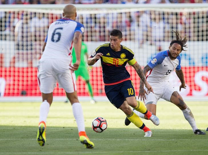 Colombia midfielder James Rodriguez controls the ball between United States defender John Brooks and midfielder