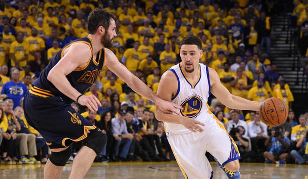 Oakland CA USA Golden State Warriors guard Klay Thompson moves the ball against Cleveland Cavaliers forward Kevin Love during the second half in game one of the NBA Finals at Oracle Arena