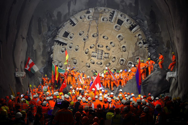 15 2010 shows miners holding national flags stand next to a giant drilling machine that completed the world's longest tunnel beneath the Swiss Alps during a ceremony