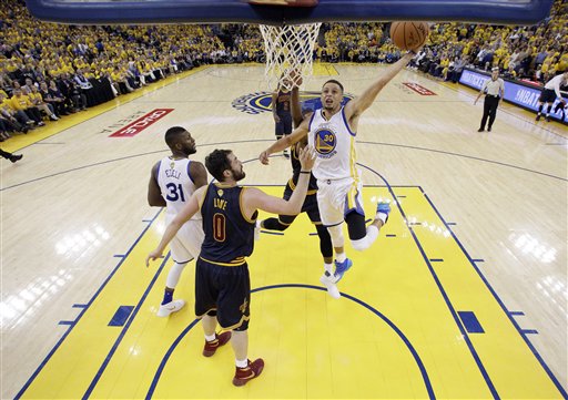 Golden State Warriors Stephen Curry drives to the basket past Cleveland Cavaliers Kevin Love during the second half in Game 1 of basketball's NBA Finals Thursday