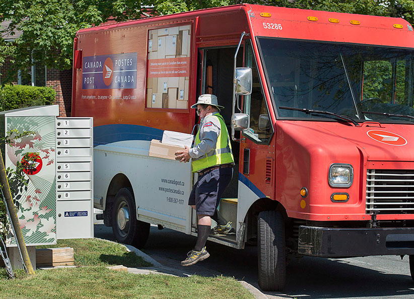 A Canada Post employee fills a community mail box in Dartmouth N.S. on Thursday