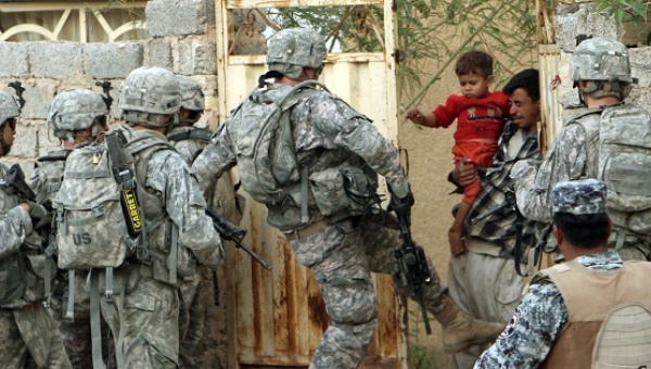 A U.S. soldier kicks a gate during a mission in Baquba in Diyala province around 40 miles northeast of Baghdad 2008