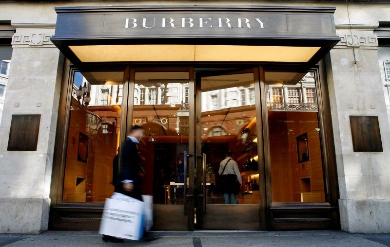 A customer walks in front of a Burberry store in central London