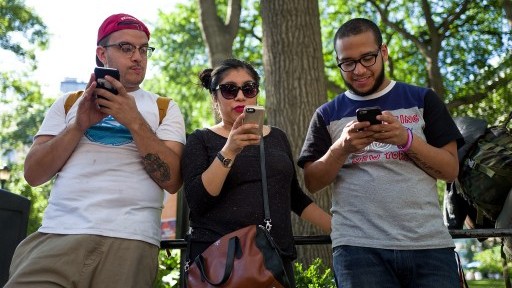 A group of friends play Pokemon Go on their smartphones at Union Square