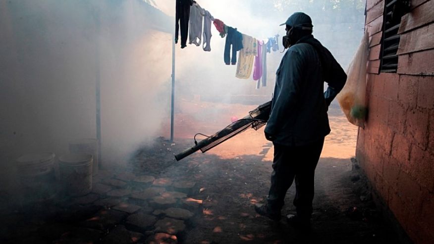 A health worker fumigates inside a home in a neighborhood in Managua