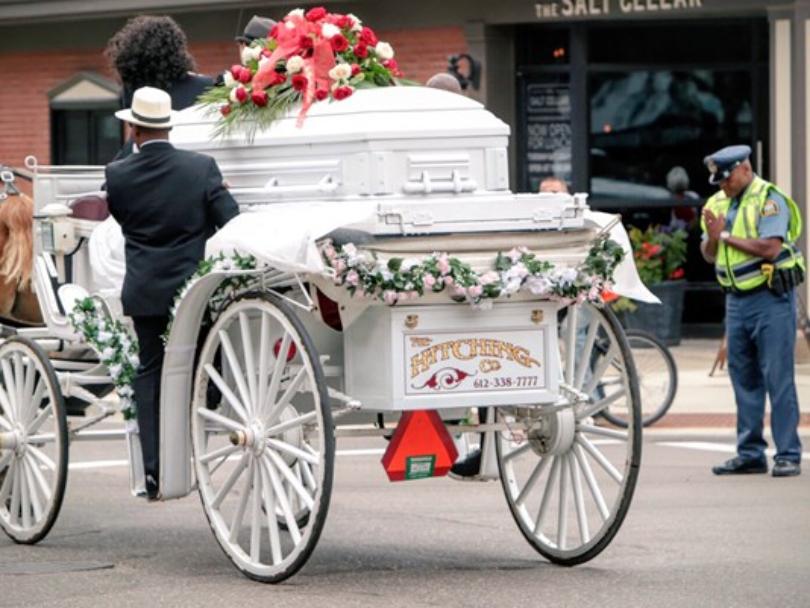 A police officer is seen praying as Philando Castile's casket leaves the funeral