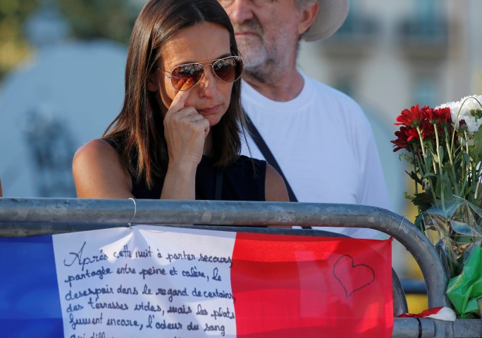 A woman grieves at a tribute to victims of the Nice attack