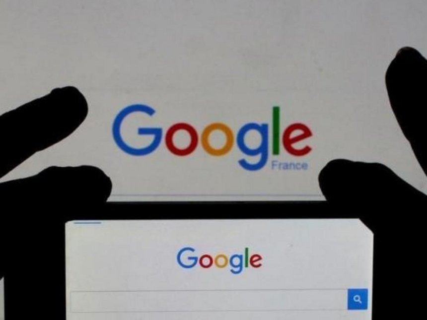 A woman holds her smart phone which displays the Google home page in this