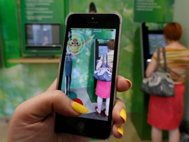 A woman plays the augmented reality mobile game ''Pokemon Go'&#039 by Nintendo