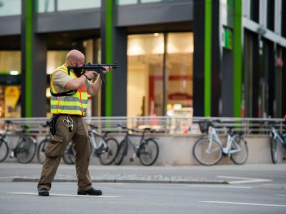 A policeman secures the area around a shopping mall ) in Munich