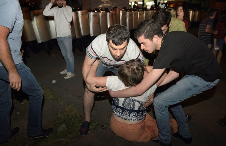 AFP  Karen Minasyan
Opposition supporters help a woman during a protest near the besieged Erebuni police station in Yerevan late