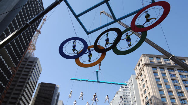 Acrobats perform on the Olympics rings at Paulista Avenue in Sao Paulo's financial center Brazil