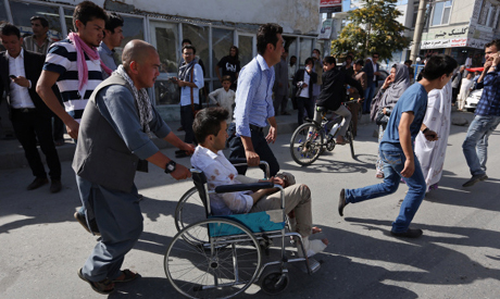 Afghans help an injured man at a hospital after an explosion struck a protest march in Kabul Afghanistan Saturday