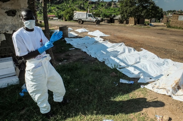 A South Sudanese ICRC worker is seen next to body bags with the remains of victims of the past days violence in Juba