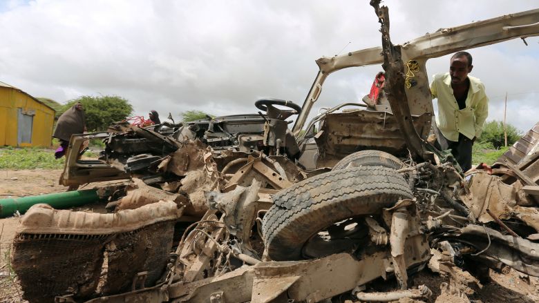 Residents gather to look at the wreckage of a minibus destroyed in roadside bomb in Lafoole village near Somalia's capital Mogadishu