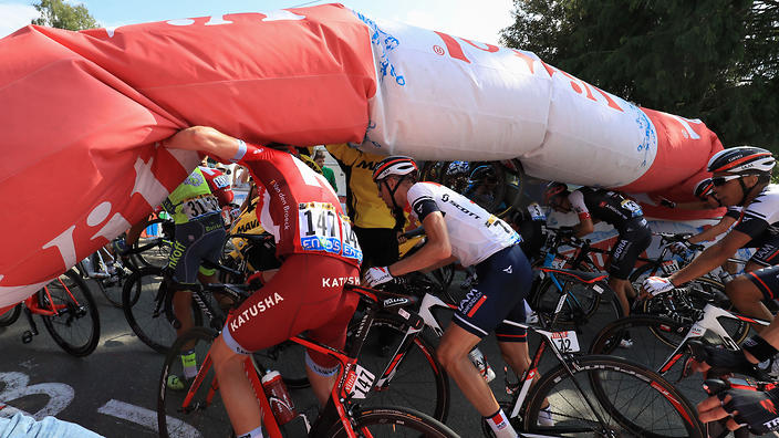 Alberto Contador Jurgen Van den Broeck and Stef Clement struggle to pass under the deflated arch of the last kilometer of Stage 7