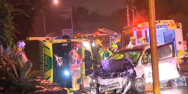 An ambulance has rolled after a speeding car crashed into the emergency vehicle on a major Auckland suburban street this morning