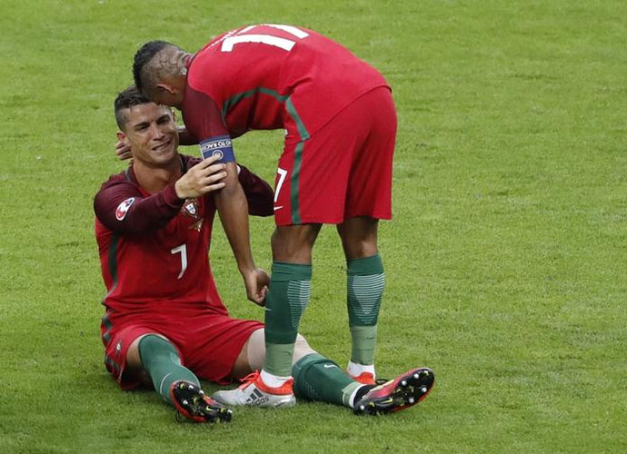 An injured and tearful Cristiano Ronaldo being comforted by Nani during the Euro 2016 final on July 10