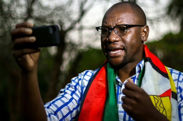 Zimbabwean cleric Evan Mawarire wrapped in the Zimbabwean National flag recording an instalment of his #ThisFlag video series in which he decries the gove