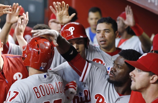 Philadelphia Phillies Odubel Herrera second from right slaps the helmet of Peter Bourjos after Bourjos scored against the Arizona Diamondbacks during