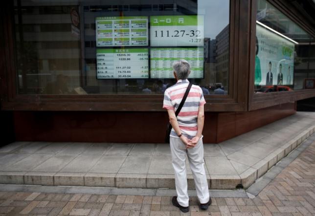 A man looks at an electronic board showing the Japanese yen's exchange rate against Euro outside a brokerage in Tokyo Japan