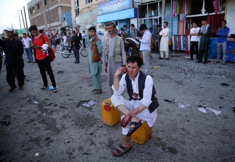 GRAPHER TO MASSOUD HOSSAINI- A bloodied man who carried dead and wounded speaks on the phone at the site of a suicide attack an explosion that struck a protest march in Kabul Afghanistan Saturday