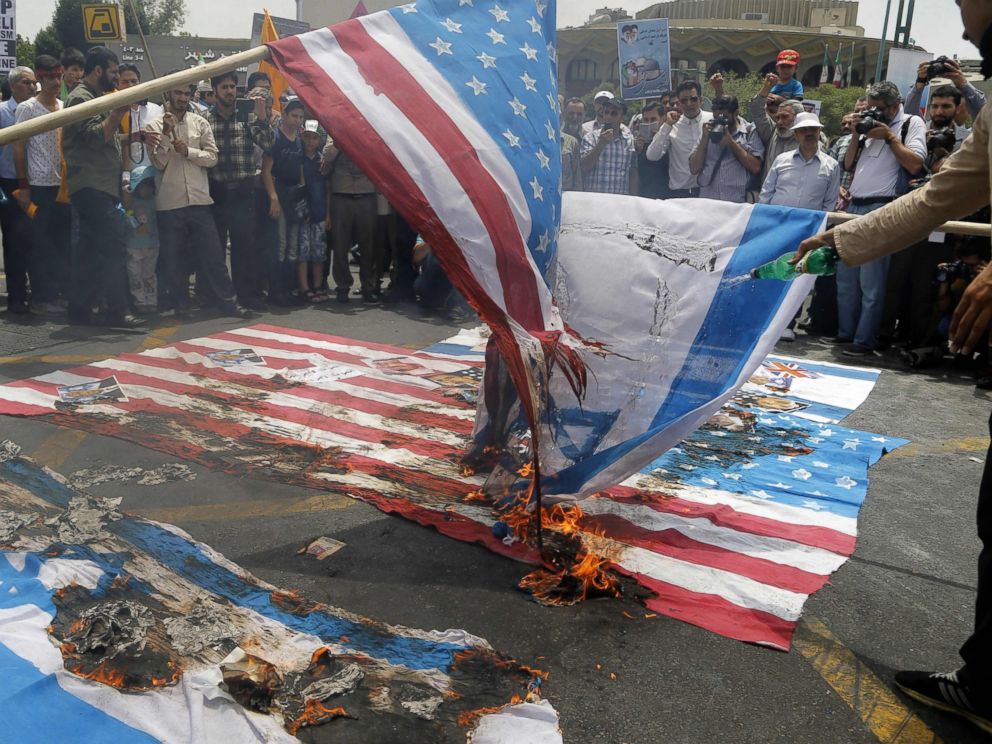 US and Israeli flags afire during a parade marking al Quds Day in Tehran