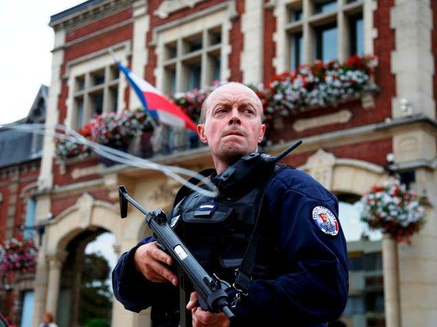 A policeman stands guard in front of the city hall after two assailants had taken five people hostage in the church at Saint Etienne-du-Rouvray near Rouen in Normandy France on Tuesday