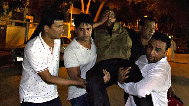 People carry an injured man near the Holey Artisan Bakery restaurant during an attack by unidentified gunmen in Dhaka's high-security diplomatic district