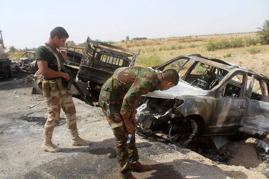 Iraqi government forces inspect charred vehicles southwest of Fallujah this week after air strikes against Islamic State fighters trying to flee the area