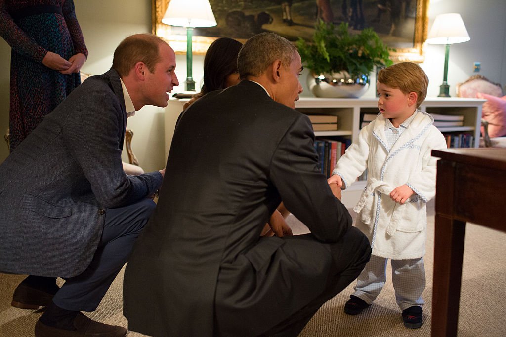 Barack Obama Prince William Duke of Cambridge and First Lady Michelle Obama talk with Prince George at Kensington Palace