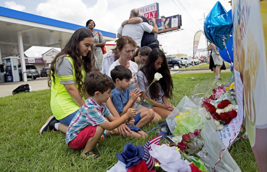 Police Shot Baton Rouge-4 A family prays in front of a memorial in front of the B Quick convenience store where three law enforcement officers were killed Sunday in Baton Rouge La