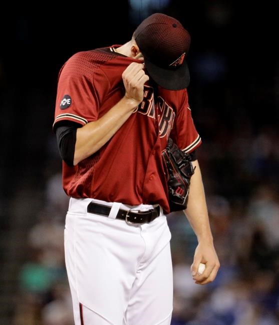 Arizona Diamondbacks starting pitcher Patrick Corbin wipes his face after giving up a two run home run against the Toronto Blue Jays during the first inning of an interleague baseball game Wednesday