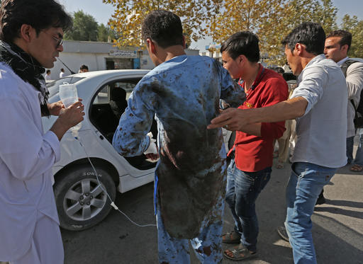 Afghans help a man who was injured in a deadly explosion that struck a protest march by ethnic Hazaras in Kabul Afghanistan Saturday