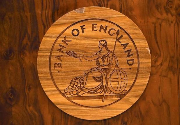 A wooden carving of the Bank of England logo is seen on a desk during a news conference at the Bank of England in London Britain