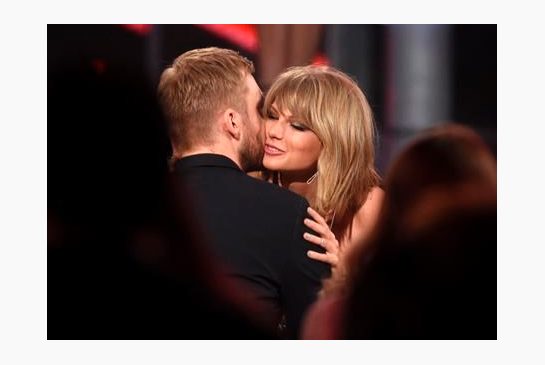 Taylor Swift right hugs Calvin Harris after winning the award for top billboard 200 album for