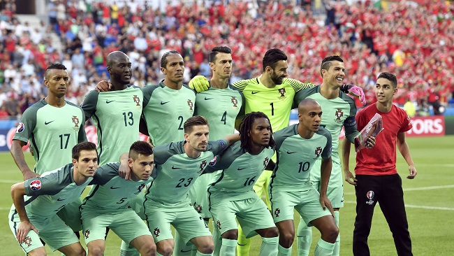 Portugal's Cristiano Ronaldo 2nd right laughs as a ball boy right joins the Portugal players during the team